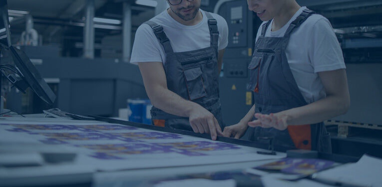 Two employees from DisplayTitan working on a printing project.