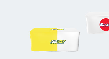 Two tables are covered with custom-made fitted tablecloths featuring branding and logos from Subway and Mastercard.